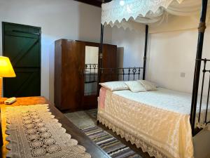 1 dormitorio con cama, lámpara y espejo en Andrianna's Cottage, en Pano Akourdalia