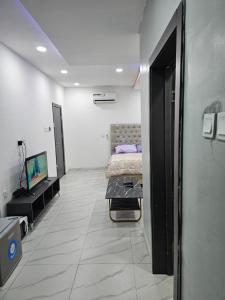 Schlafzimmer mit einem Bett und einem Flachbild-TV in der Unterkunft Hencapservices 002HPS. in Agege
