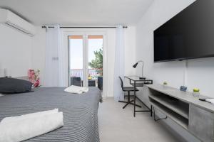 Schlafzimmer mit einem Bett, einem Schreibtisch und einem TV in der Unterkunft Luxury Seaview Apartment in Juraši