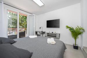 um quarto com uma cama e uma televisão na parede em Luxury Seaview Apartment em Juraši