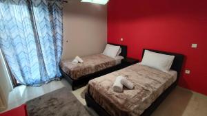 2 camas en una habitación con paredes rojas en Spata sunrise house, en Spáta