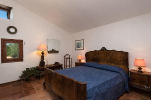 una camera da letto con un letto con copriletto blu e 2 lampade di B&B Mulino Marsa a CastellʼArquato