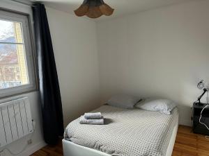 Un pequeño dormitorio con una cama con toallas. en Appartement proche Grenoble centre et campus, en Saint-Martin-dʼHères