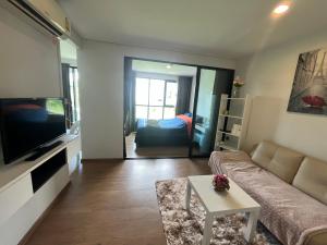 ein Wohnzimmer mit einem Sofa und einem TV in der Unterkunft 1 bedroom Centrio Condominium Phuket Near Central Festival in Phuket town in Phuket