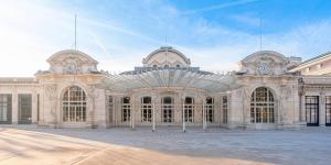 een groot stenen gebouw met twee koepels bovenop bij Logis Hôtel Belle Etoile Vichy in Vichy