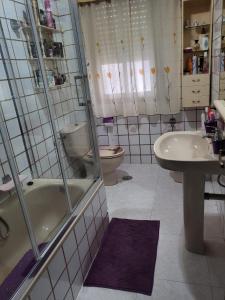 ein Badezimmer mit einem WC, einer Badewanne und einem Waschbecken in der Unterkunft EL BUDHA in Pobra do Caramiñal