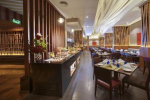 a restaurant with tables and chairs and a bar at Ramee Rose Hotel in Manama