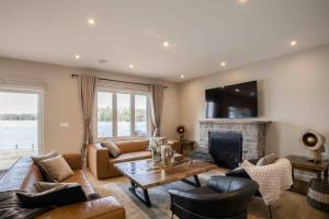 ein Wohnzimmer mit Couch und Kamin in der Unterkunft Cozy front lake cottage! in Hindon Hill