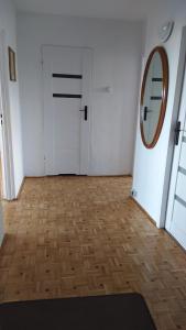 Pokój z białymi drzwiami i lustrem w obiekcie Uroczy apartament z bezpłatnych parkingiem w Warszawie