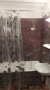 łazienka z zasłoną prysznicową i umywalką w obiekcie Uroczy apartament z bezpłatnych parkingiem w Warszawie