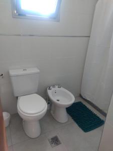 a white bathroom with a toilet and a sink at Alma de Acacia Lodge in San Rafael