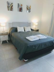 - une chambre avec un lit et 2 serviettes dans l'établissement Alma de Acacia Lodge, à San Rafael