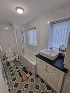 uma casa de banho com um lavatório, uma banheira e um WC. em 1 bedroom Windy Nook -Great monthly offers em Sheriff Hill