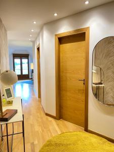 een hal met een houten deur en een spiegel bij Apartamento boutique con terraza y vistas al mar. Porto Vilanova in Villanueva de Arosa