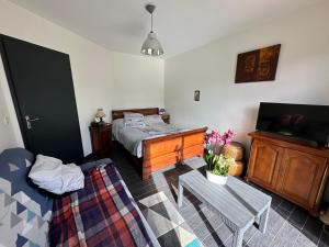 a bedroom with a bed and a table in it at chambre équipée in Panazol