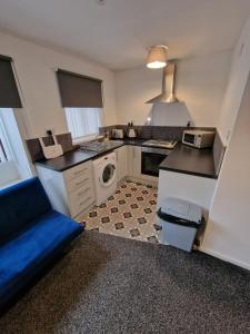 a kitchen with a blue couch in a room at 1 bedroom Windy Nook -Great monthly offers in Sheriff Hill