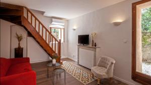 - un salon avec un canapé rouge et un escalier dans l'établissement Casa Anto - Au coeur de Calenzana, à Calenzana