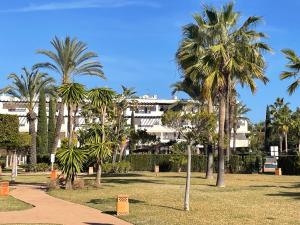 un gruppo di palme in un parco con un edificio di CASA AZUL Mojácar a Mojácar