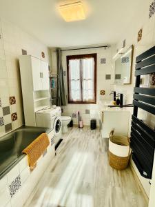 a bathroom with a sink and a washing machine at Gîte de la Cigale in Burzet