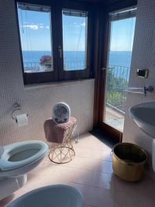 ein Bad mit 2 WCs, einem Waschbecken und einem Fenster in der Unterkunft Villa Stone Positano in Positano