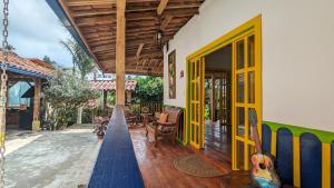a house with yellow doors and a porch at Charming Coffee Farm House in Salento