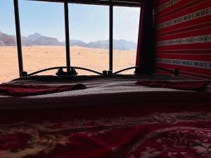 a bedroom with a bed with a desert view at Wolf Trail Adventure in Wadi Rum