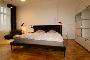 ein Schlafzimmer mit einem Bett und einer Kommode in der Unterkunft Zentrales hochwertiges Gründerzeit-Apartment Thomasius in Leipzig