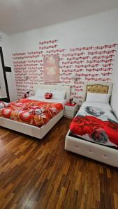 ナポリにあるB&B Blue Crystalの赤い壁のベッドルームにベッド2台が備わります。