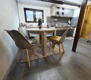 a kitchen with a wooden table and two chairs at Vikendica Banjska Diva in Ovčar Banja