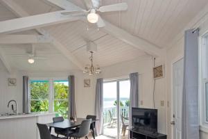 a dining room with a table and a ceiling fan at OceanBliss: Exuma, Waterfront sleeps 8 in Michelson