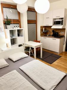 uma cozinha e sala de estar com armários brancos e uma mesa em Mini Studio em Čakovec