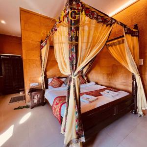 a bedroom with a canopy bed with curtains at Hotel Grand Heritage Jaisalmer in Jaisalmer