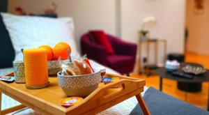 a wooden table with a bowl of oranges on it at Appartement F2 idéalement situé in Caen