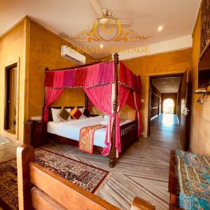 Hotel Grand Heritage Jaisalmer في جيلسامر: غرفة نوم بسرير مع مظلة