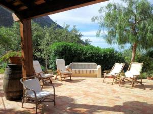 grupa krzeseł i ławka na patio w obiekcie Dolce Dormire Home Holiday w mieście Castellammare del Golfo