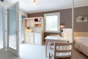a bedroom with a bed and a desk and a kitchen at Residence Gonda&Giuliano in Borso del Grappa