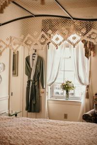 a dress hanging in a room with a window at The Richard Johnston Inn & 1890 Caroline House in Fredericksburg