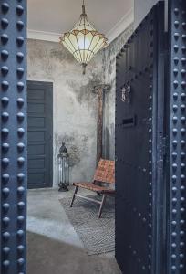 une chambre avec un banc et un lustre dans l'établissement Riad Atay, à Marrakech