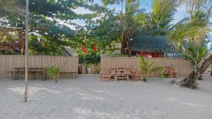 a patio with a table and chairs in front of a fence at Balai Ko - Tent 1 in Locaroc