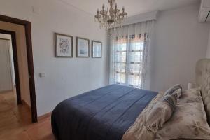 1 dormitorio con cama, lámpara de araña y ventana en Mansion Alhamar Apartment, en Sitio de Calahonda 28 fotos más