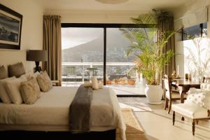 ein Schlafzimmer mit großem Bett und ein Esszimmer in der Unterkunft Radium Hall Guest House in Kapstadt