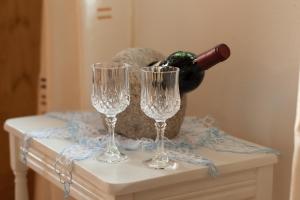 two wine glasses on a table with a bottle of wine at Fachwerk Ferienhaus Elz in Elz +28 photos