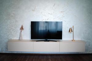 a television on a white cabinet in a room at Downtown Apartment in Râmnicu Vâlcea