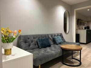 a living room with a gray couch and a table at Lovely tiny house in Zandvoort