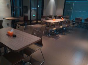 um restaurante vazio com mesas e cadeiras com velas de laranja em 7Days Inn Shijiazhuang Pingshan Zhongshan Road em Pingshan