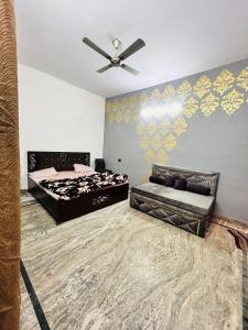 a bedroom with two beds and a ceiling fan at Agrawal Inn Guest House in Mathura