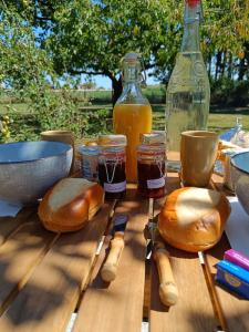 two loaves of bread and jars of honey on a table at Tente mongole " ô Rêves Atypiques" in Boucé