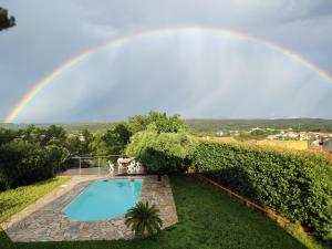 un arc-en-ciel au-dessus d'une piscine avec une piscine dans l'établissement Amazing view ! Great house to gather with friends in Provence, à Gréasque
