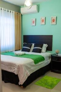 1 dormitorio con 1 cama grande y paredes azules en Confortable apartamento- Cotuí, en Cotuí