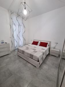a bedroom with a bed with red pillows on it at CASA VERDi 37 CAMERA RUBINO SMERALDO in Porto SantʼElpidio